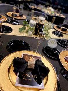 a black and gold table setting with place settings