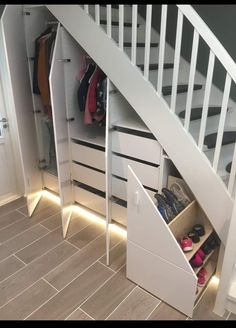 an open closet under the stairs with shoes