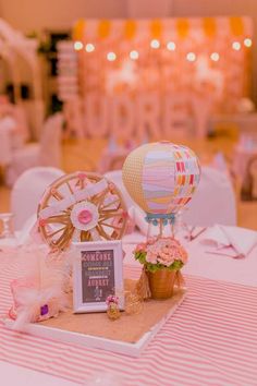 hot air balloons are sitting on the table at a wedding reception with pink and white decor