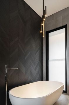 a white bath tub sitting next to a black wall