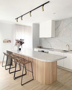 a kitchen with marble counter tops and stools