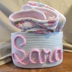 a white basket with pink letters on it