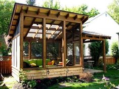 a small wooden gazebo sitting on top of a lush green field