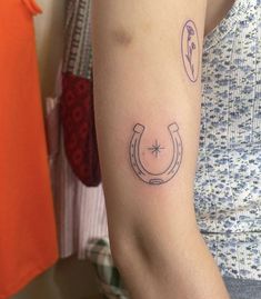 a woman with a horseshoe tattoo on her arm