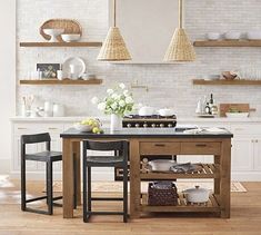 a kitchen with white walls and wooden flooring, two stools at the table