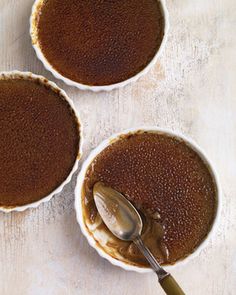 two small white bowls filled with food and a spoon