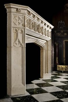 an ornate fireplace in a room with black and white checkered flooring on the ground