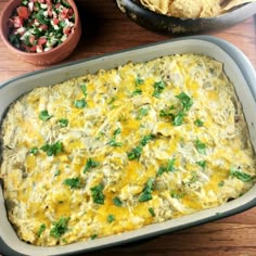 a casserole dish in a pan with tortilla chips on the side