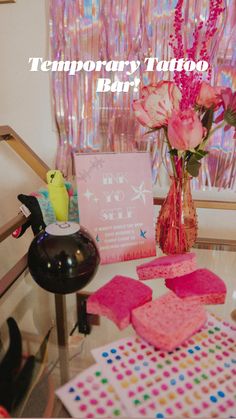 a vase with pink flowers on top of a table next to other items and decorations