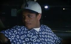 a man wearing a baseball cap sitting in the back seat of a car at night