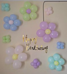 balloons and streamers with the words happy birthday written in gold foil on a wall