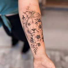 a woman's arm with a lion and flowers on it