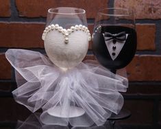 two wine glasses decorated with tuxedos and pearls