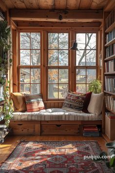 a living room filled with lots of books and furniture next to a window covered in windows