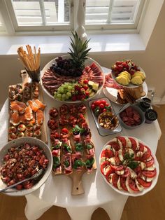 a table topped with lots of different types of fruit and veggie platters