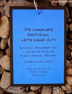 a blue birthday card hanging from a metal hook on a pile of rocks with the words it's charlie's birthday let's hang out