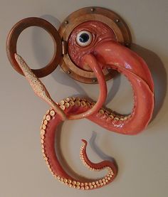 an octopus is hanging on the wall next to a pair of scissors and eyeballs