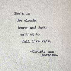 an old typewriter with the words she's in the clouds, heavy and dark, waiting to fall like rain