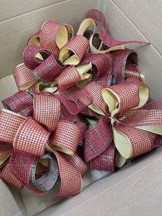 a box filled with lots of pink and green ribbons