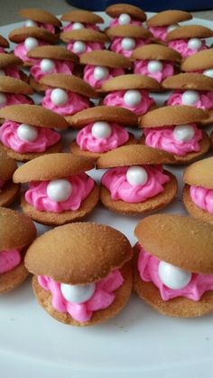 some cookies with pink frosting and marshmallows on them