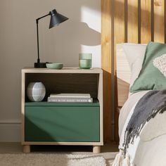 a nightstand with books on it and a lamp next to it in a bedroom setting