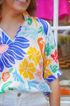 Get lost in the paradise ahead with this lightweight blouse featuring a unique floral print in vibrant colors. It has raglan sleeves, a notched v-neckline, and a delicate ruffle trim that adds a touch of femininity. Perfect for summer, this top pairs beautifully with white shorts or your favorite denim. It is lightweight, slightly sheer, and has a loose fit. Brand- THML Model is 5'8" and is wearing a small Red Clover, The Paradise, New Arrival Dress, Ruffle Trim, Raglan Sleeve, Savannah Chat, White Shorts, Paradise, Floral Print