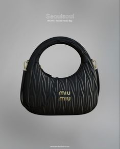 a black handbag with gold logo on the front and side, hanging from a hook