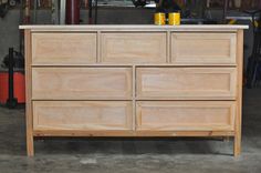 a wooden dresser sitting inside of a garage