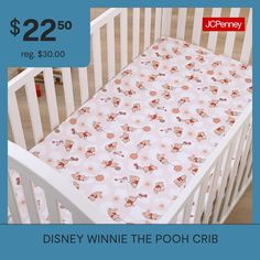 a baby crib with a disney winnie the pooh sheet on it