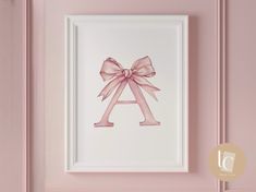 a pink bow is hanging on the wall next to a white framed art print that says a