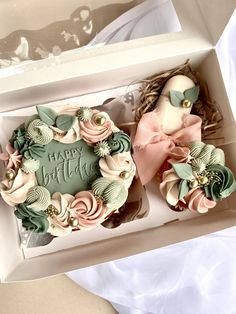 two cupcakes in a box decorated with flowers