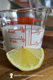 a measuring cup filled with liquid and a lemon slice