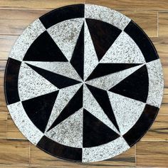 a black and white circular tile on the floor with an arrow in it's center