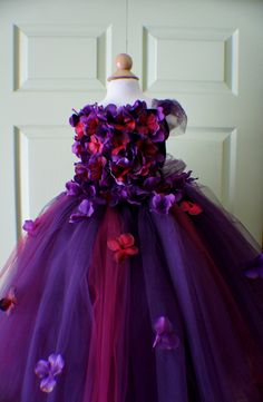 a dress made out of tulle with flowers on the front and purple petals on the back