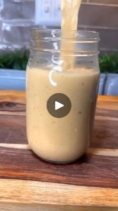 a jar filled with liquid sitting on top of a wooden table