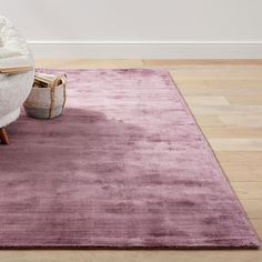 a purple rug with a chair and book on it