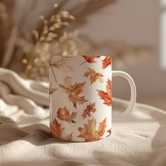 a coffee cup sitting on top of a bed covered in leaves