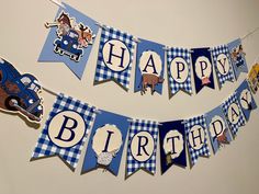 a blue and white birthday banner with farm animals on it that says happy birthday hanging from the wall