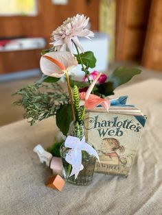 a vase filled with flowers on top of a table next to a book and some paper clips