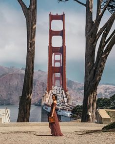 a woman standing in front of the golden gate bridge