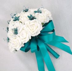 a bridal bouquet with white roses and blue ribbon