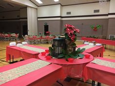 a banquet hall set up with tables, chairs and flowers on the centerpieces