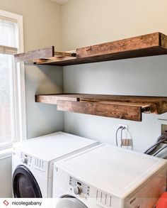 a washer and dryer in a room with open shelving on the wall