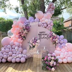 an outdoor birthday party with balloons and flowers