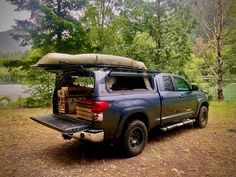 a pick up truck with an awning on the back is parked in front of some trees