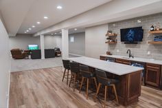 a large kitchen and living room with wood flooring