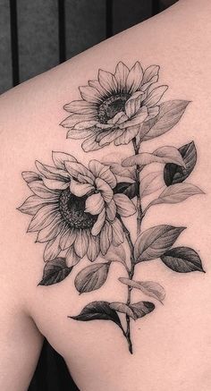 a sunflower tattoo on the back of a woman's left side ribcage