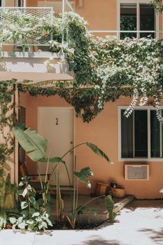 an apartment building with plants growing on the outside