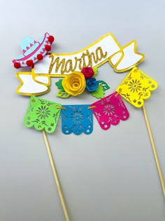 a cake topper with the name martha on it and some colorful decorations around it