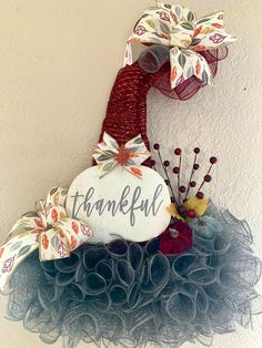 a sign that says, thank you with flowers and leaves on it hanging from the side of a wall